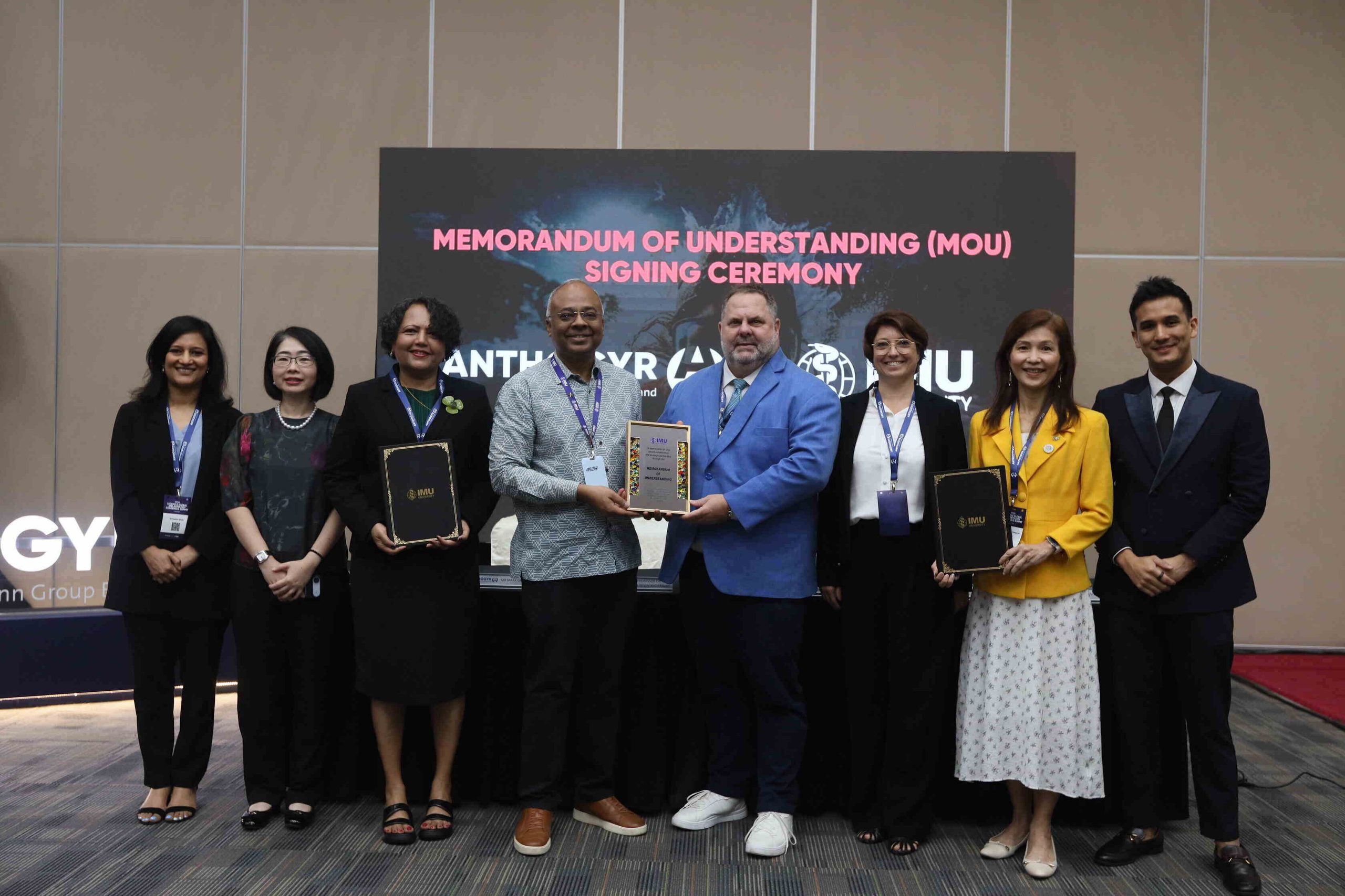 Group of IMU University and Straumann Group representatives posing with a commemorative plaque during the MoU ceremony